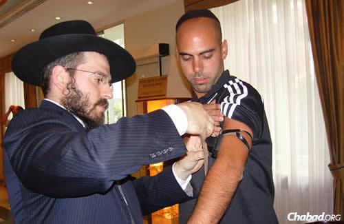 הרב אליעזר גוראריה מסייע ליהודי להניח תפילין. &quot;הנקמה הטובה ביותר&quot;