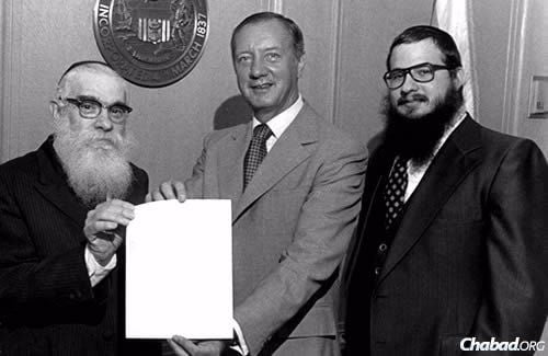 Rabbi Moscowitz, right, came to his hometown of Chicago in 1976 to assist Rabbi Solomon S. Hecht, left, head Chabad emissary of Illinois. Here, they are shown with Michael Anthony Bilandic, the 49th mayor of Chicago and former Chief Justice of the Illinois Supreme Court.