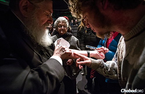 People waited in line to examine the rabbi's number imprinted on his arm, which marked him as an inmate. (Photo: Eliott Foust)