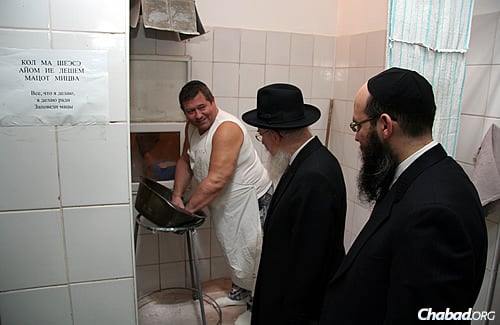 A worker mixes the dough as the former chief rabbi of Ukraine, Rabbi Azriel Chaikin, center, observes. To the right is Rabbi Mayer Stambler, a Chabad emissary in Dnepropetrovsk and director of the Federation of Jewish Communities of Ukraine.