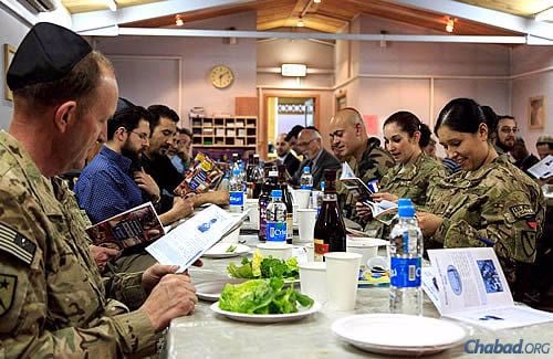 Looking over the Haggadahs before the seder starts for military personnel. (Photo: The Aleph Institute)