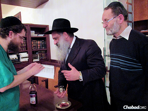 The mohel, Mordechai Tzvi Salamon, left, with the rabbi and Pasternak