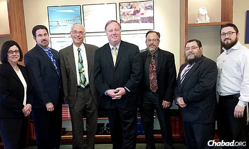 Rabbi Mendel Teldon, far right, director of Chabad of Mid Suffolk, and Rabbi Yaakov Saacks, second from right, director of the Dix Hills Jewish Chai Center, both on Long Island, with Jewish communal leaders and Commack High School administrators, including school principal Dr. Donald James, center, at a joint meeting to discuss follow-up after a recent anti-Semitic incident.