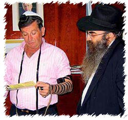 Nahariya’s mayor Jacki Sabag dons tefillin with the Chabad emissary to Nahariya