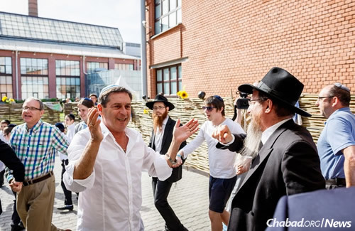 Rabbi Berel Lazar celebrates with community members. (Photo: Levi Nazarov)