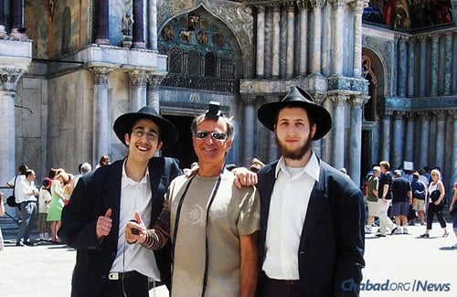 Two yeshivah students wrap tefillin with a Jewish man at the Piazza San Marco in Venice, Italy. The piazza was the site of a public burning of the Talmud in 1553. (Photo: Mordechai Lightstone)