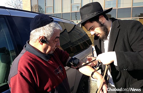 A mitzvah familiar to the yeshivah student: Helping a man don tefillin. (Photo: Lubavitch Mesivta of Chicago)