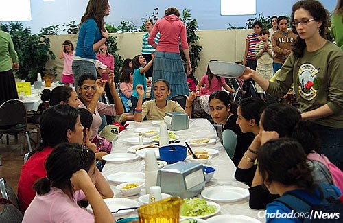 Lunch hour at Camp Running Springs in California offers time for socializing and group song. These girls were brought to America for a month of adventure and entertainment on a Chabad grant to help those at risk from the war-torn southern Israeli city of Sderot. They all suffered from post-traumatic stress disorder. (Photo: mushkaphotography.com)