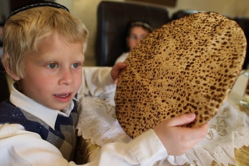 A boy holds up a round, whole matzah (not photographed on the holiday) - Photo: Flash90