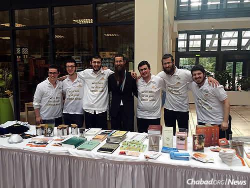 A table of information for players and fans, provided by Chabad. As their shirts read: “We&#39;re here for all your Jewish needs!” In the center is Rabbi Shmuel Segal, program director for Chabad of Berlin.