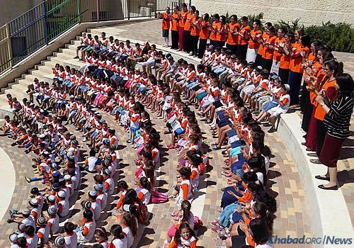 Preparing for a photo of Chabad summer day campers in the Har Homa neighborhood of Jerusalem.
