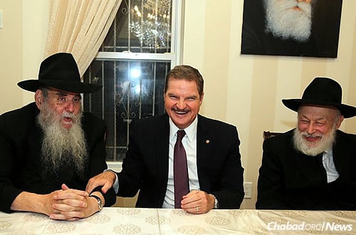 A reception was held in Eman’s honor in the sukkah of Rabbi Moshe and Rivka Kotlarsky. Here, he talks with Rabbi Kotlarsky, left, and Rabbi Yehuda Krinsky, chairman of Merkos L’Inyonei Chinuch, which has been sending young rabbinical students to visit Aruba’s Jews for more than 20 years.