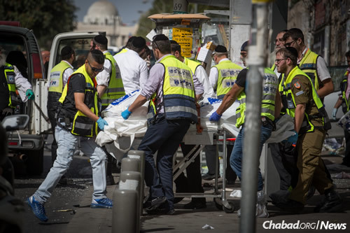 Rescue workers on Malchei Yisrael Street in Jerusalem after a terrorist rammed his car into pedestrians, and then got out and stabbed others, killing one man and injuring at least five people. (Photo: Hadas Parush/FLASH90)