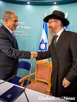 Israeli Prime Minister Bejamin Netanyahu greets Chief Rabbi of Russia Berel Lazar at a group meeting on Sunday night. (Photo: Ezekiel Itkin)