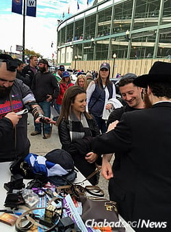 Wrapping tefillin for Jewish passersby.