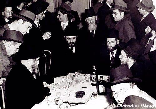At his wedding reception, Feigelstock is flanked by the Rebbe and Rabbi Menachem Zeev (Volf) Greenglass. Behind him to the right is his father, with whom he had reunited after years of separation.
