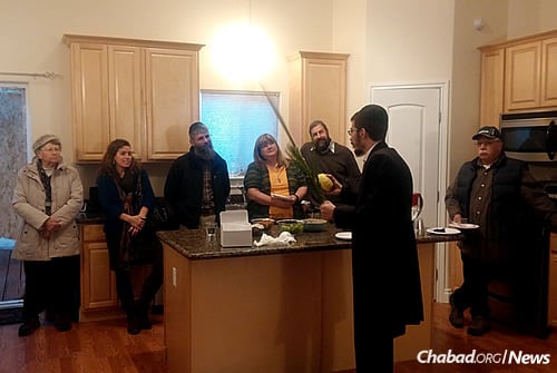 Rabbi Mendy Greenberg helps community members in Wasilla, Alaska, shake the lulav and the etrog over the Sukkot holiday in his home and new Chabad House that he co-directs with his wife, Chaya.
