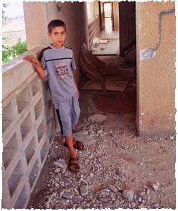Baruch Shimoni, 9, stands amidst the rubble in a neighborhood building