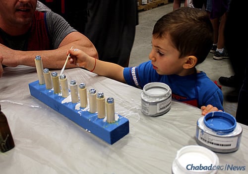Three-year-old D.J. Becker paints a menorah at a Chanukah workshop sponsored by Chabad at St. Johns County in Florida and Lowe's home-improvement store.