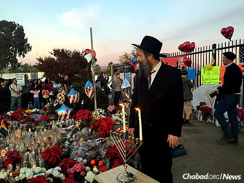Rabbi Sholom Harlig, co-director of Chabad of the Inland Empire in Rancho Cucamonga, Calif., has been lighting a menorah at the site of the San Bernardino terror attacks that occurred last week, which left 14 people dead. Here, he is seen with onlookers on the first night of Chanukah.