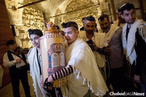 Naor Shalev Ben-Ezra carries a Torah scroll as he celebrates his bar mitzvah with family and friends at the Western Wall in Jerusalem&#39;s Old City. The 13-year-old was critically injured in a stabbing attack two months ago in the Pisgat Ze&#39;ev neoghborhood of Jerusalem. (Photo: Yonatan Sindel/Flash90)