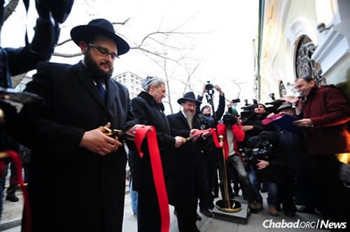 Rabbi Shimon Varakin, left, rabbi of the Jewish community of Vladivlostok, cutting the ribbon along with Rabbi Lazar and other dignitaries.