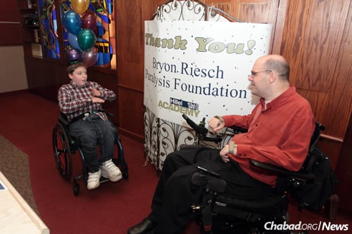 Shmuely Tebbitt, left, with Bryon Riesch, whose charitable foundation provided the boy with a new wheelchair, thanks to the initiative of Shmuley's classmates at Hillel Academy in Milwaukee.