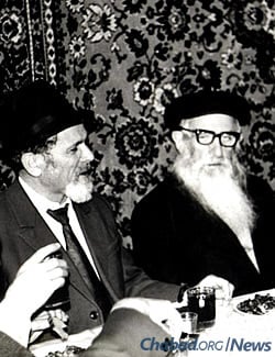 Reb Mottel Lifshitz (left), known as Reb Mottel der Shoichet for his work as a ritual slaughterer, sits next to Reb Getche at a Moscow farbrengen in the 1980s.