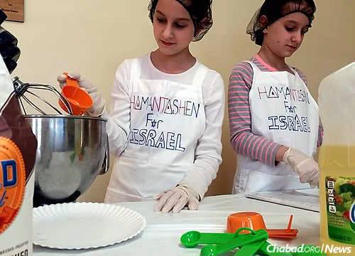 Chaya Mushka and Esther Leah Hodakov, 11-year-old twins from Florida, are baking and selling hamantaschen in the weeks before Purim to raise funds to be sent to terror victims in Israel.