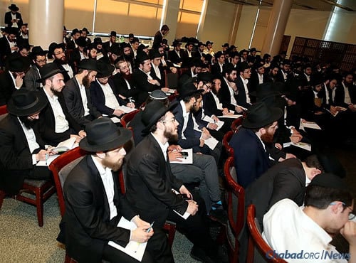 Yeshivah bochurs at a presentation in New York get ready to travel to 300 cities worldwide to assist with Passover preparations and conduct seders. (Photo: Itzik Roytman)