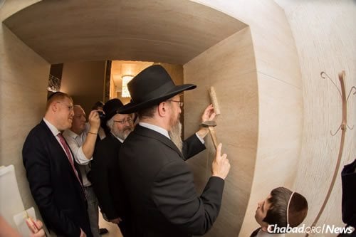 Rabbi Lazar affixes the mezuzah at the mikvah entrance.