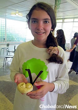 Showing off a homemade creation last year at the first Gan Israel Yeka camp for girls.