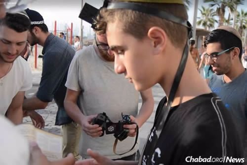 Wrapping tefillin on the streets of Tel Aviv.