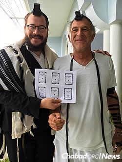 Rabbi Yaakov Raskin, left, with the unbound pages of a new Tanya in Port Antonio.