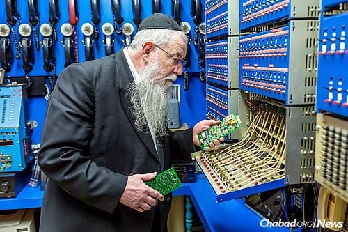 Rabbi Halberstam shows some of the custom-built computer hardware installed in the early 1990s. (Photo: Eliyahu Yosef Parypa/Chabad.org)
