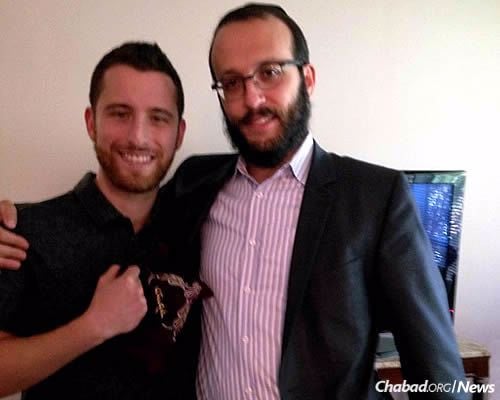 Dustin, left, the son of a man named Aubie who was visited by Rabbi Levi Gansburg, right, co-director of Chabad Lubavitch of York Mills in Toronto, Canada, holds tefillin wrapped by his father. They were given to him as a gift soon after his father passed away.