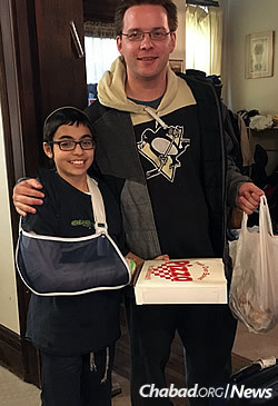 Pitt graduate Dima Harmon visits Levi Weinstein, kosher pizza in hand, while he was recuperating from a broken wrist and concussion. The Chabad emissaries and students have formed lasting bonds.