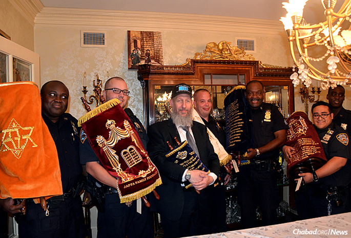 A Torah is on its way for use in Austin, Texas, dedicated to five police officers who were killed in the line of duty this summer. Here, representatives of the New York City Police Department participate in a ceremony in memory of the fallen officers. Third from left is Bentzion Chanowitz, who runs the daily operations of the Beis Yisroel Torah Gemach. (Photo: Alex Bodnar)