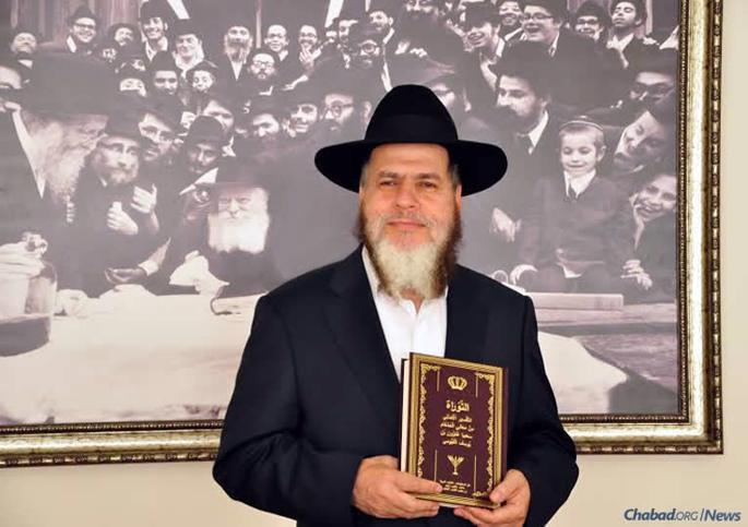 Rabbi YomTov Hakohen Guindi holds the first edition of his modern rendering of Rabbi Saadia Gaon’s Arabic-language Tafsir.