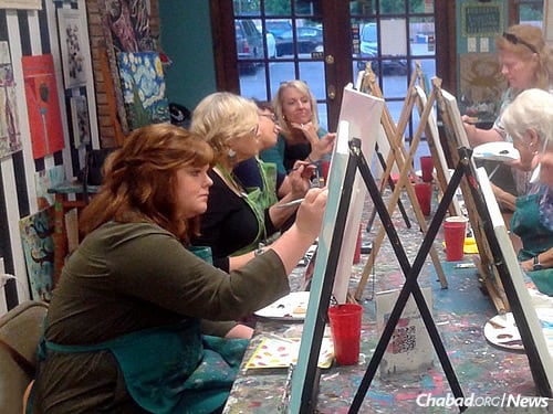 Women work on art a “paint night” activity prior to Shavuot.