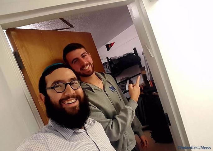 Rabbi Meir Rapoport helps student David Vaknin hang a mezuzzah at Stockton University in Galloway Township, N.J., where he and his wife, Shaina, recently started a campus Chabad House.