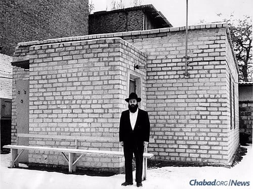 Success came slowly in the beginning, and a mikvah was one of them. Kaminezki stands in front of Dnepropetrovsk's then-new mikvah in the early 1990s.