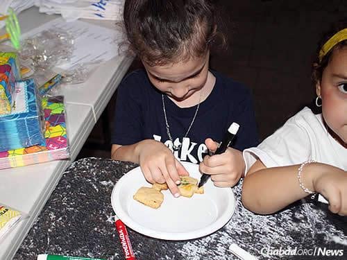 Children make decorations at Chanukah time.