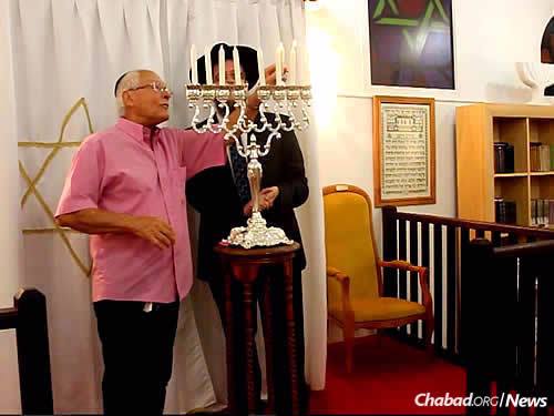 Guy Flak lights the Chanukah menorah.